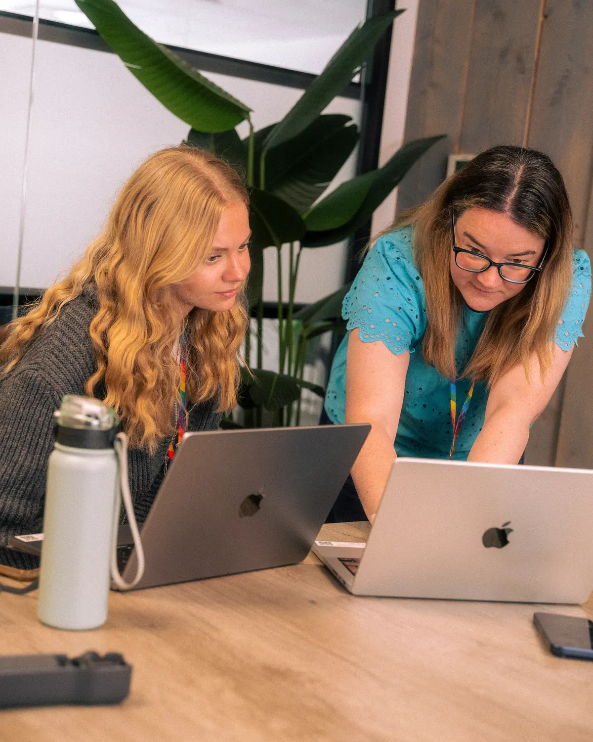 Exposure Marketing team reviewing laptop work together at a table.